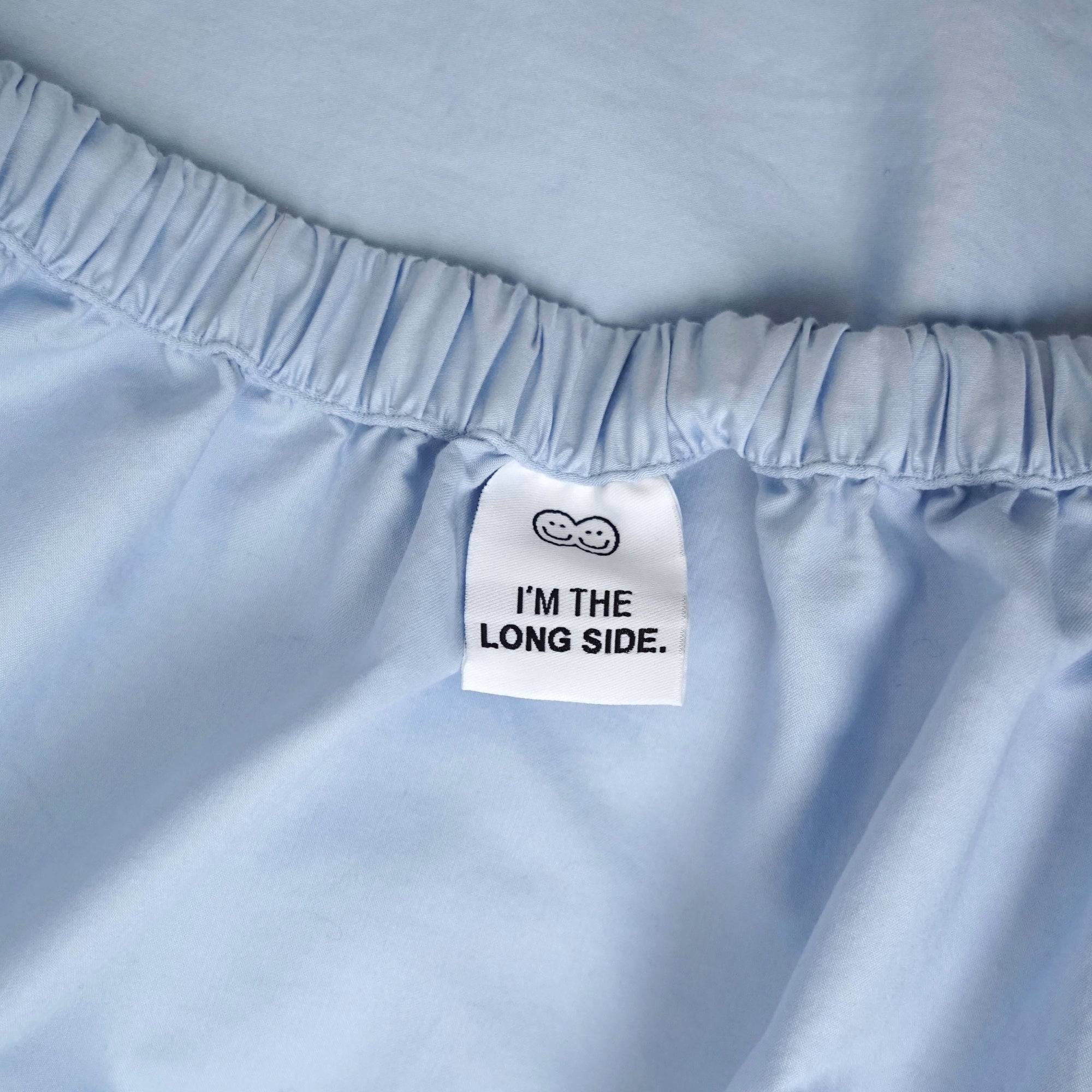 Roomie blue organic cotton fitted sheet with long side tag 
