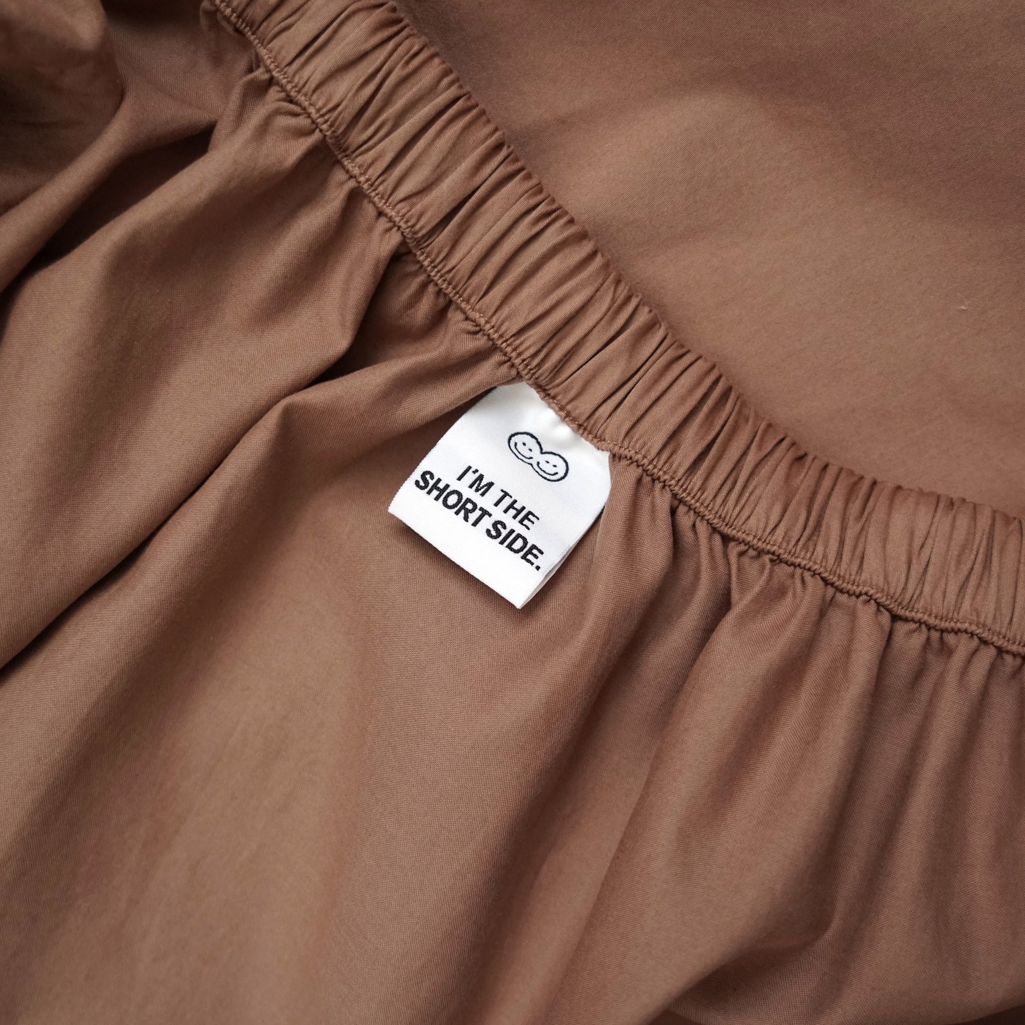 Roomie brown organic cotton fitted sheet with guide tag