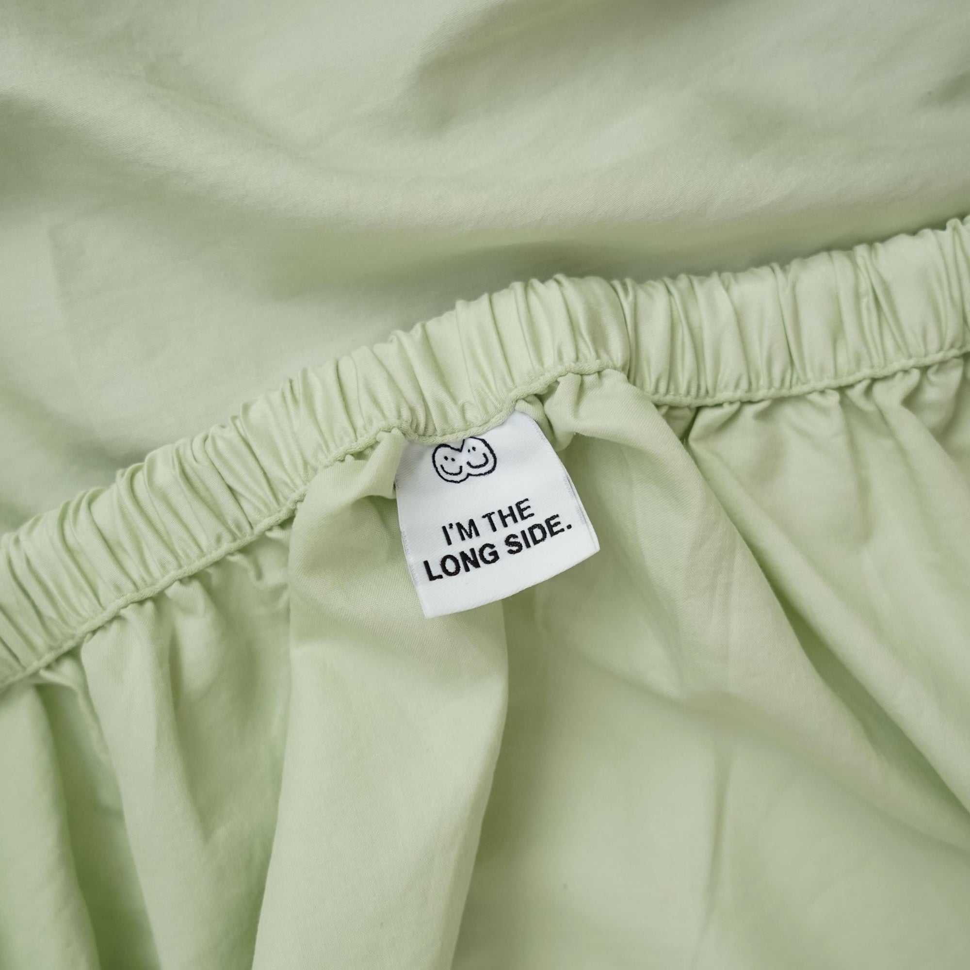 Roomie matcha green organic cotton fitted sheet with tag guide